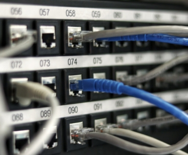 Panneau de brassage rseau numrot avec des cbles Ethernet bleus et gris branchs dans les ports